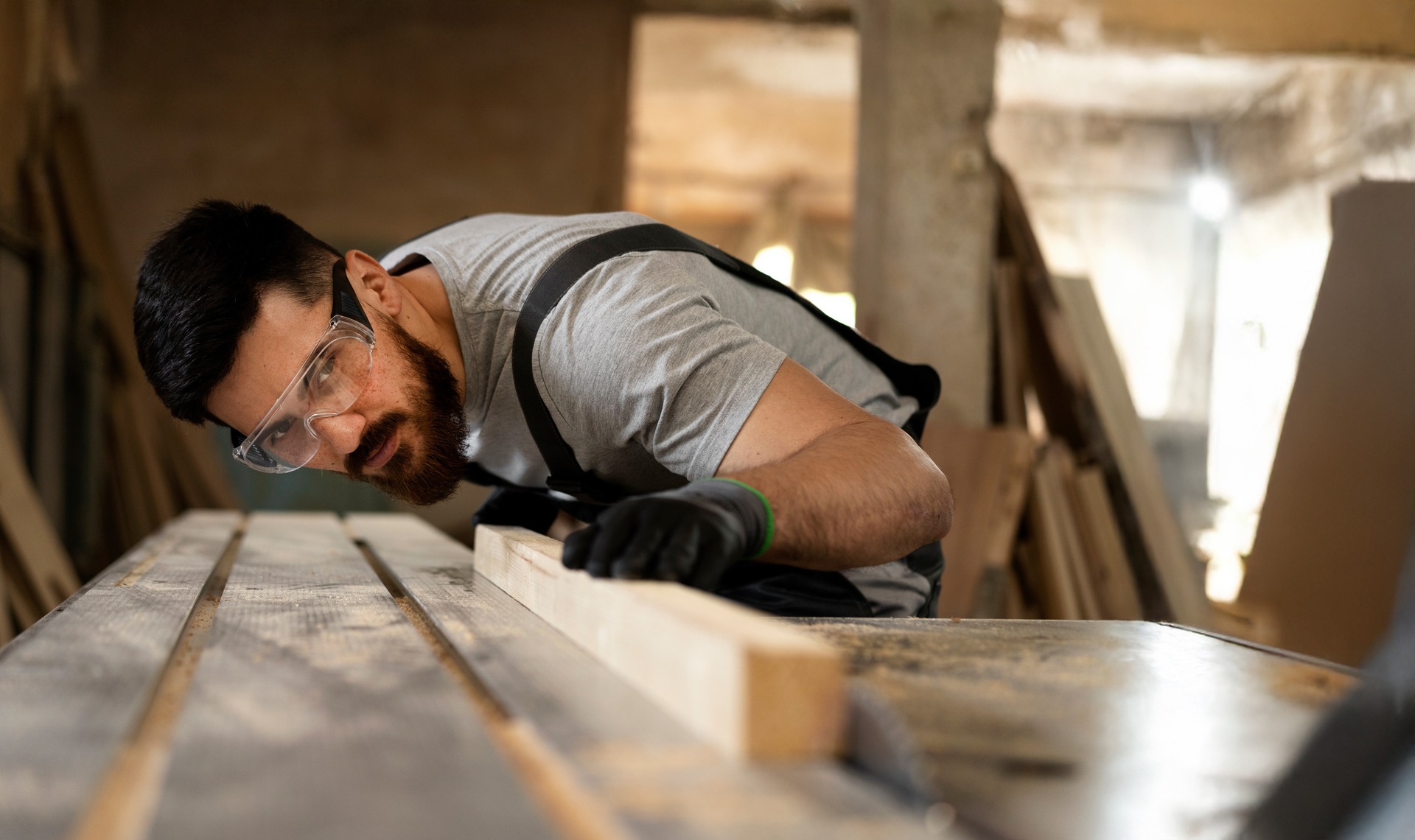 Carpenter cutting MDF board inside workshop